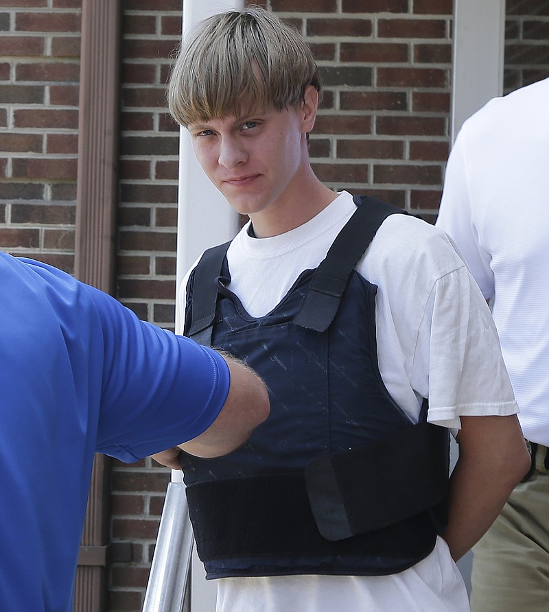 
              FILE - In this June18, 2016 file photo, Dylann Storm Roof is escorted from the Sheby Police Department in Shelby, N.C. The trial for Roof, a white man accused of killing nine black people at the church, started Wednesday, Dec. 7, 2016, at the federal courthouse in Charleston, S.C. (AP Photo/Chuck Burton, File)
            