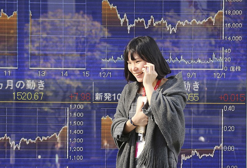 
              A woman walks by an electronic stock board of a securities firm in Tokyo, Friday, Dec. 9, 2016. Asian shares meandered Friday as an overnight rally in U.S. markets helped by the European Central Bank's decision to extend its bond-buying economic stimulus program faded. (AP Photo/Koji Sasahara)
            