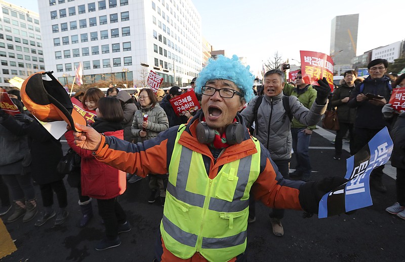 
              A protester dances after hearing the President Park Geun-hye's impeachment in front of the National Assembly in Seoul, South Korea, Friday, Dec. 9, 2016. South Korean lawmakers on Friday voted to impeach President Park Geun-hye, a stunning and swift fall for the country's first female leader amid protests that drew millions into the streets in united fury. (AP Photo/Lee Jin-man)
            