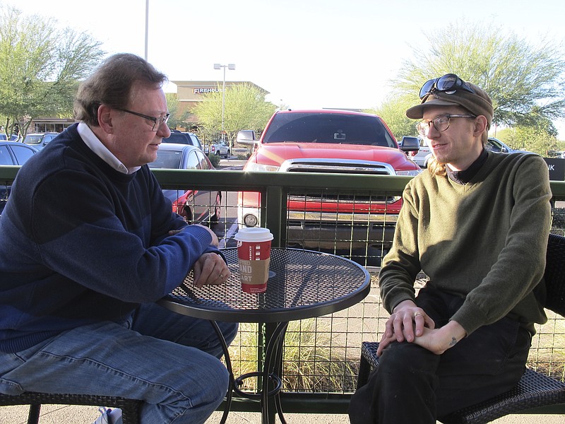 
              Christopher Farstad, right, a musician from Minneapolis, speaks with his father, James, at a coffee shop Friday, Dec. 9, 2016, in Gilbert, Ariz. Farstad was among a group of people attending a music event inside a warehouse in Oakland, Calif., on Friday night, Dec 2, 2016, when a fire tore through the building, killing dozens of people. He described the scene as a "hellish situation." (AP Photo/Brian Skoloff)
            