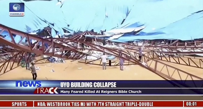 
              In this image taken from video people stand at the scene after the roof of The Reigners Bible Church International collapsed onto worshippers in Uyo, southern Nigeria on Saturday, Dec. 10, 2016, killing dozens, witnesses and an official said. (Channels TV via AP)
            