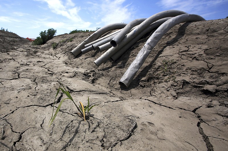 
              FILE - In this May 18, 2015 file photo, irrigation pipes sit along a dry irrigation canal on a field near Stockton, Calif. The House has approved a wide-ranging bill to approve water projects across the country, including $170 million to address lead in Flint, Michigan’s drinking water and $558 million to provide relief to drought-stricken California.  (AP Photo/Rich Pedroncelli, File)
            