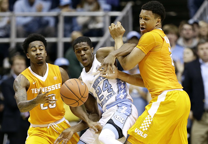North Carolina's Kenny Williams, center, gets tangled up with Tennessee's Jordan Bowden, left, and Grant Williams, while battling for the ball during Sunday's game in Chapel Hill, N.C.