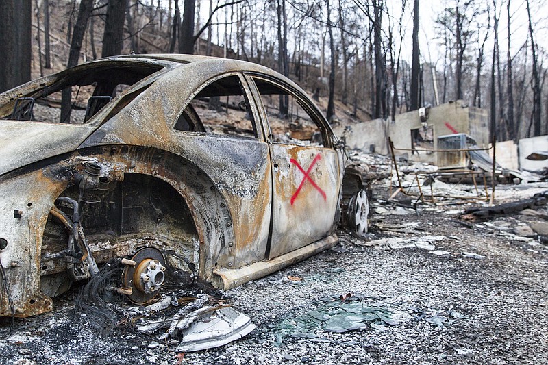 A burned vehicle sits in a heavily damaged neighborhood above Gatlinburg, Tenn., on Friday, Dec. 9, 2016. The resort town reopened to the public for the first time since wildfires on Nov. 28. (AP Photo/Erik Schelzig)