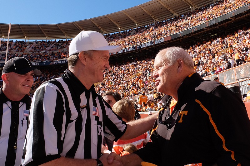 Former head coach Phil Fulmer greets referees at halftime of the Tennessee homecoming football game in Knoxville in mid-November, 2015.