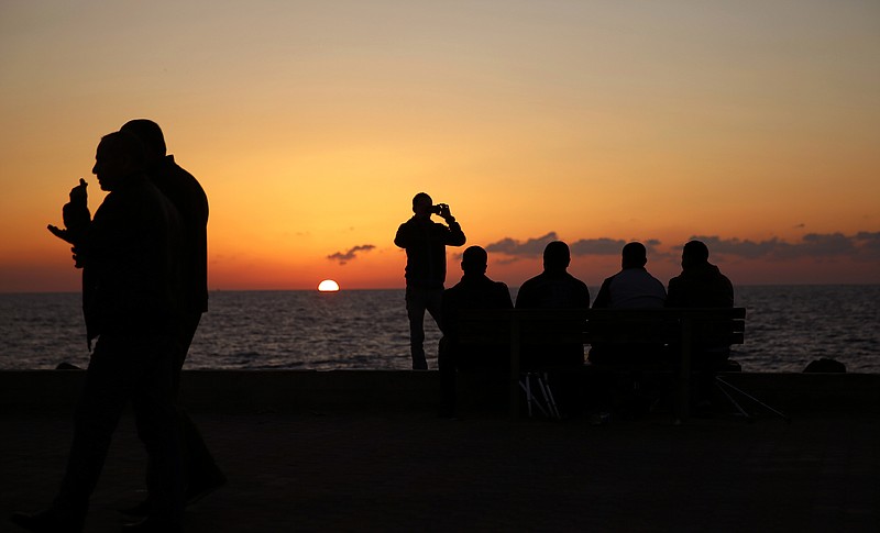 
              Palestinians sit on a chair during the sunset, at the Gaza port, in Gaza City, Monday, Dec. 12, 2016. The harbor is one of the few open public spaces in this densely populated city. (AP Photo/Hatem Moussa)
            