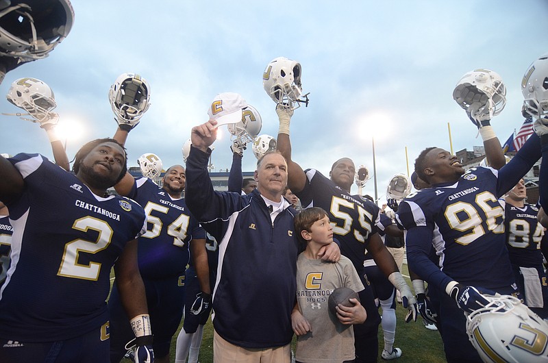 UTC players, and coach Russ Huesman, center, with son Levi Huesman, sing the alma mater after defeating Indiana State Saturday at Finley Stadium.