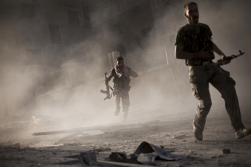 Free Syrian Army fighters run away after attacking a Syrian Army tank during fighting in the Izaa district in Aleppo, Syria, Friday, Sept. 7, 2012. (AP Photo/Manu Brabo, File)