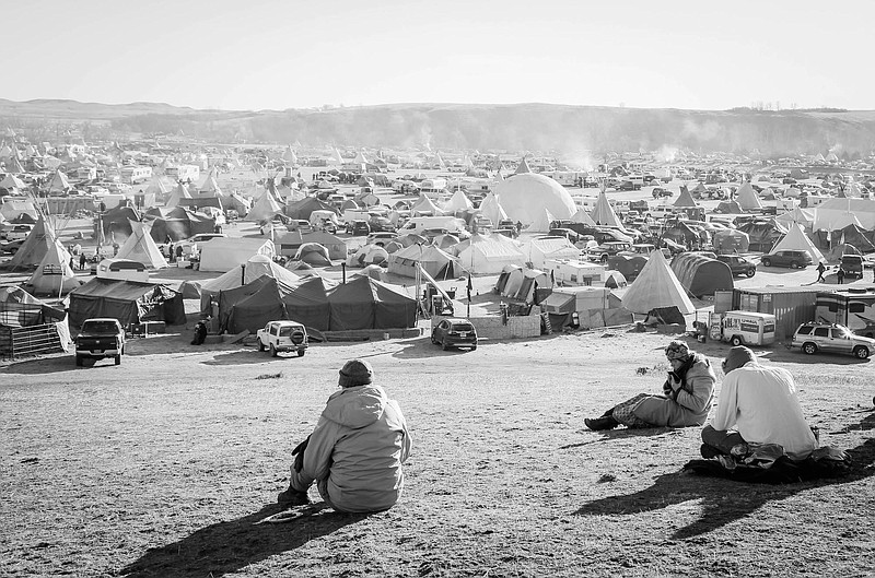 Water Protectors and peaceful protesters at the Oceti Sakowin camp look out over the frigid landscape at sunrise.Photo by Allison KendrickMembers of the Oceti Sakowin camp look out over the frigid landscape at sunrise. The community is one of several camps housing native Water Protectors and peaceful protestors from around the world.