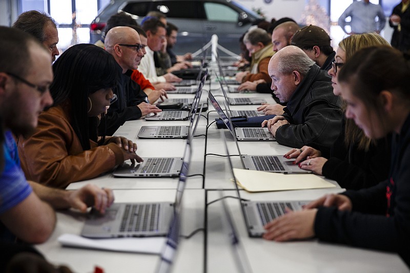 Job-seekers fill out applications during a job fair with Volkswagen staffing contractor Aerotek held at the Volkswagen Manufacturing Plant on Friday, Dec. 16, 2016, in Chattanooga, Tenn. Aerotek is hiring to fill production slots for manufacturing Volkswagen's new Atlas SUV.