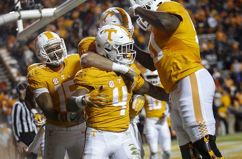 Players pile onto Tennessee runningback John Kelly (4) after a touchdown during the Vols' home football game against the Missouri Tigers at Neyland Stadium on Saturday, Nov. 19, 2016, in Chattanooga, Tenn. Tennessee won their final home game of the season 63-37.