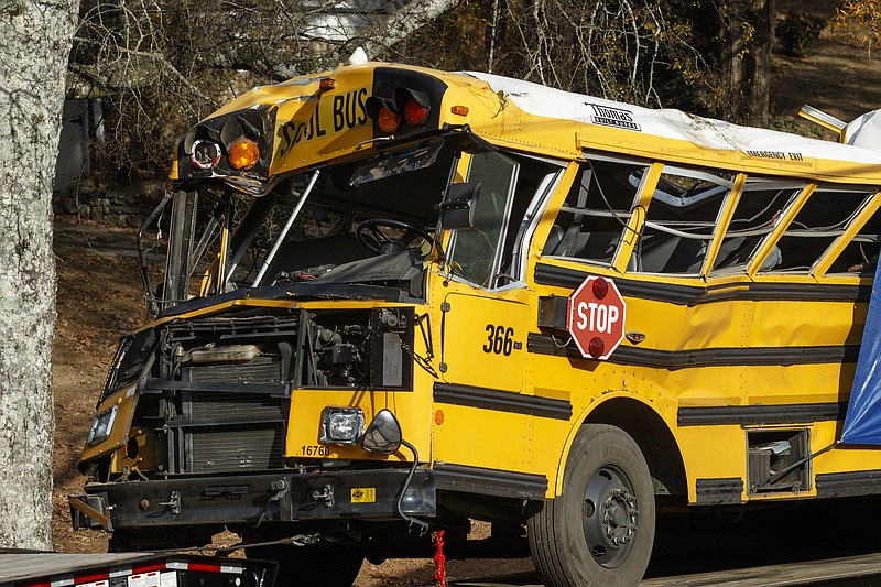 A wrecker removes the school bus from the scene of a crash on Talley Road on Tuesday, Nov. 22, 2016, in Chattanooga, Tenn. The Monday afternoon crash killed at least 5 elementary schoolchildren and injured dozens more. The NTSB has been called in to help investigate.