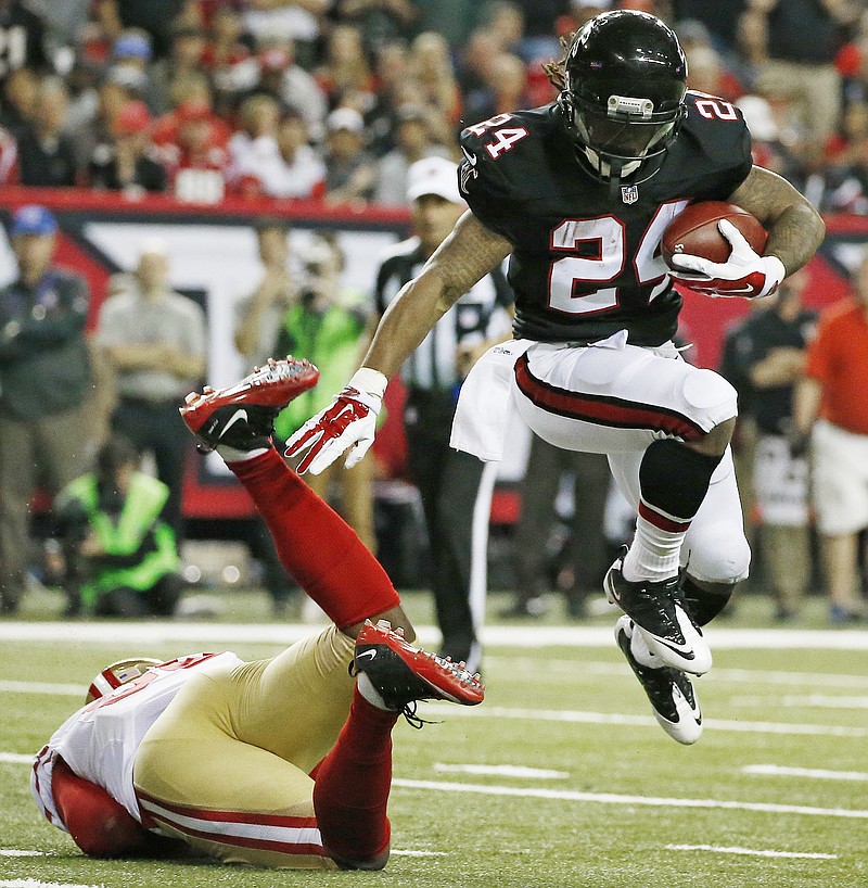 Atlanta Falcons running back Devonta Freeman (24) runs by San Francisco 49ers outside linebacker Eli Harold (58) during the first half of an NFL football game, Sunday, Dec. 18, 2016, in Atlanta. (AP Photo/Butch Dill)

