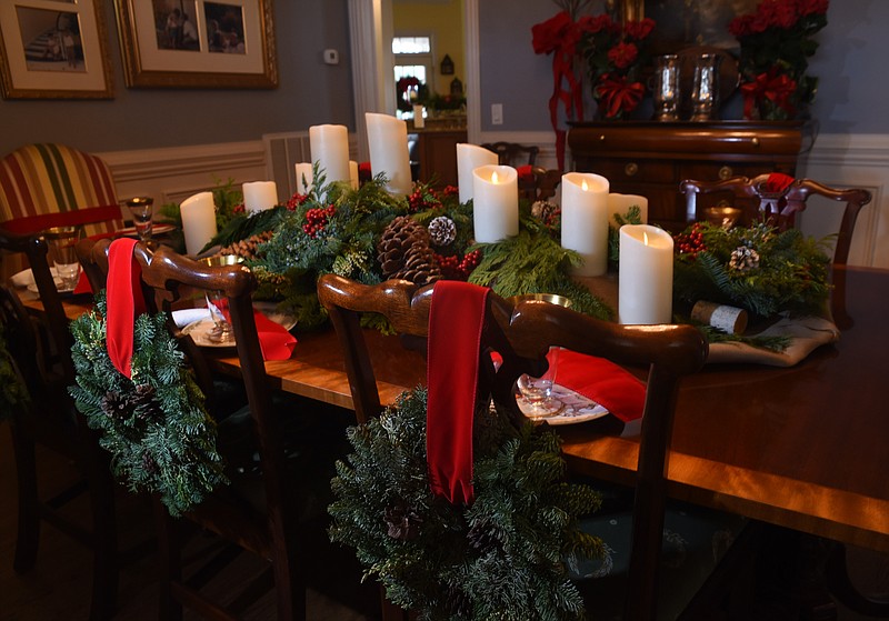 Use a loop of red velvet ribbon to tie a small fir wreath to the back of each dining-table chair to add to the holiday spririt.