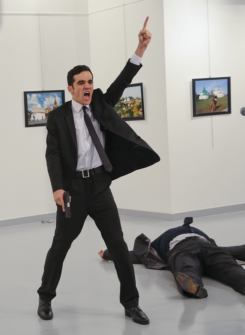 
              FILE - In this Monday, Dec. 19, 2016 file photo, Mevlut Mert Altintas shouts after shooting Andrei Karlov, right, the Russian ambassador to Turkey, at an art gallery in Ankara, Turkey. At first, AP photographer Burhan Ozbilici thought it was a theatrical stunt when a man in a dark suit and tie pulled out a gun during the photography exhibition. The man then opened fire, killing Karlov. (AP Photo/Burhan Ozbilici)
            