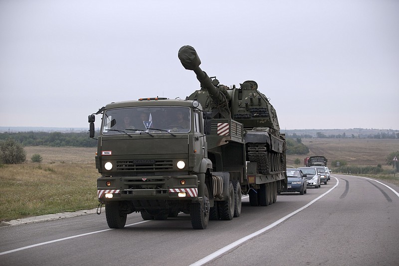 
              FILE - In this Tuesday, Aug. 19, 2014 file picture, a Russian military truck carries a MSTA-S self-propelled howitzer about 10 kilometers from the Russia-Ukrainian border control point at town Donetsk, Rostov-on-Don region, Russia. Russian howitzers and rocket launchers regularly pounded Ukrainian positions across the border in the early stages of the war in eastern Ukraine, according to an analysis of hundreds of attack sites published by open source investigative group Bellingcat. (AP Photo/Pavel Golovkin, File)
            