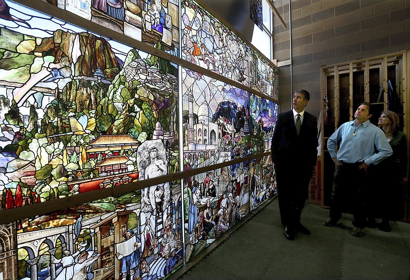 Utah Valley University President Matthew Holland, left, and Tom and Gayle Holdman look at the progress of "The Roots of Knowledge" at Holdman Studios in Lehi, Utah. The 80-panel stained-glass project recently was at the UVU Library. (Laura Seitz/The Deseret News via AP)