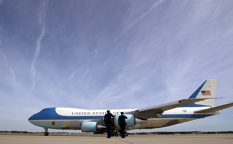 Military personnel salute as the current Air Force One departs at Andrews Air Force Base, Md.