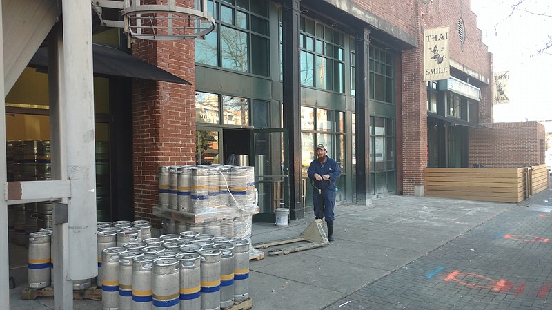 Staff Photo By Mike Pare / Moe's Original Bar B Que is to open early next year on Market Street in space adjacent to Big River Grille and Brewing Works. Tanner Chamberlain, an assistant brewer at Big River, readies a pallet at the site.