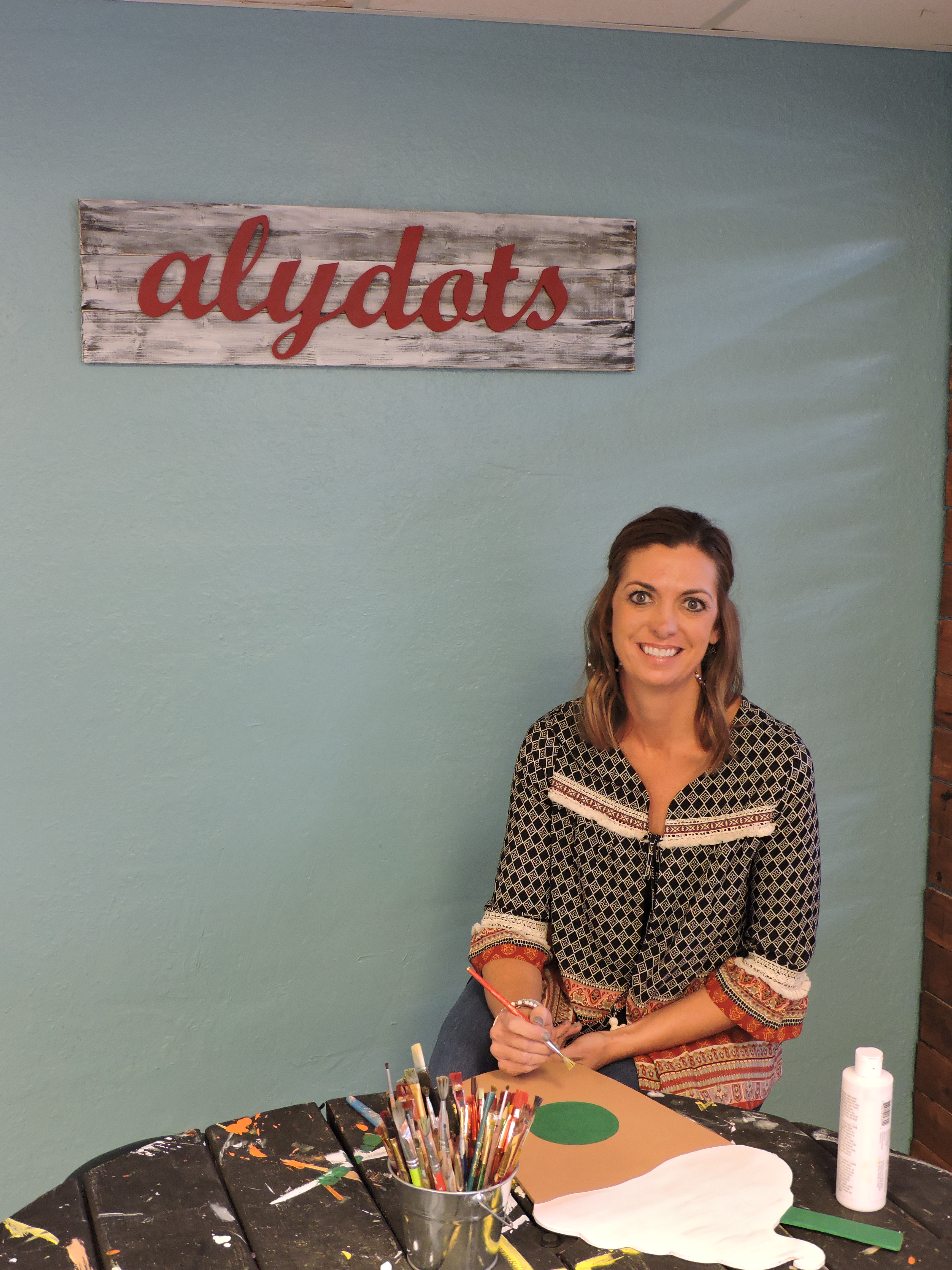 Alydots owner Alyson Tunnell creates a Starbucks cup-shaped door hanger at her new studio in Ringgold.