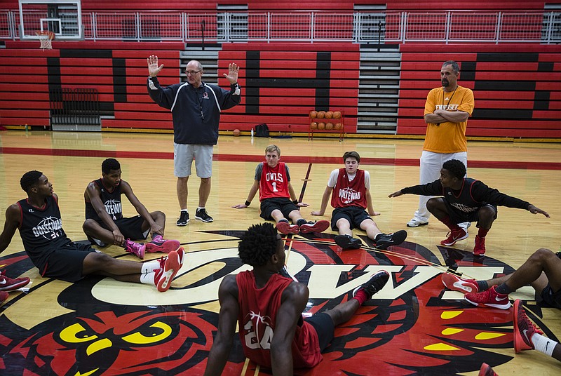 New Ooltewah basketball coach Jay Williams, left, talks to players at the end of basketball practice at Ooltewah High School on Tuesday, Dec. 20, 2016, in Ooltewah, Tenn. One year after former players on the team sexually assaulted a teammate during an overnight trip to Gatlinburg, the program is rebuilding.