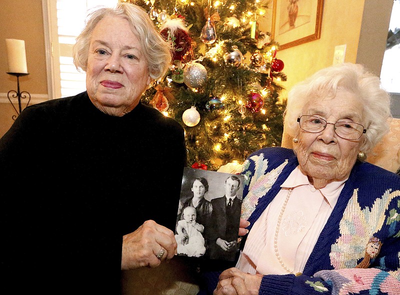 
              ADVANCE FOR WEEKEND EDITIONS - In this Wednesday, Dec. 14, 2016, photo, Ann Coleman, left, holds a photo next to her mother Virginia Austin in Murfreesboro, Tenn. The photo shows Austin as a baby with her parents father Francis Marion Snell, and mother Mattie Lou Jernigan. Family members of 100-year-old Austin hope to give her a special gift: the long-lost wedding ring of her mother. And they’re offering a $1,000 reward to get it back. (Helen Comer/The Daily News Journal via AP)
            