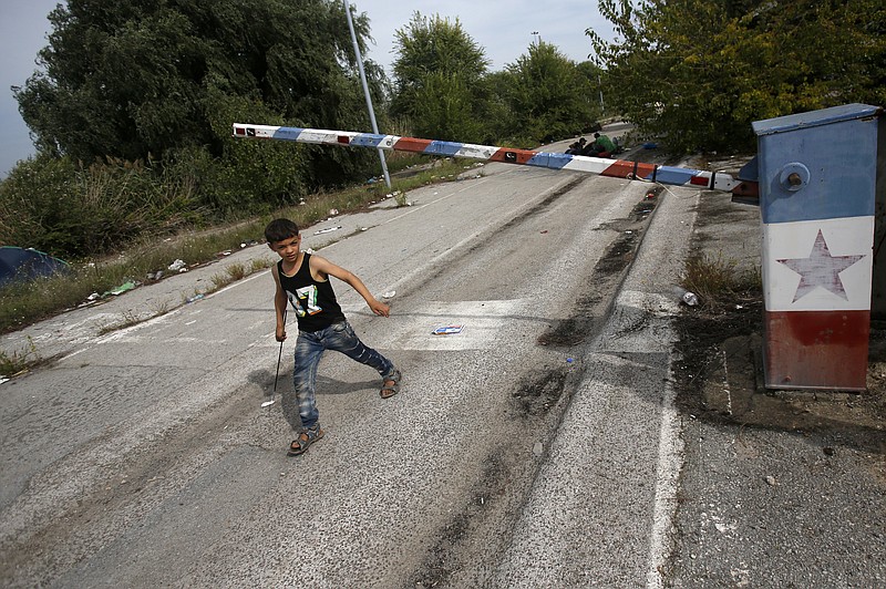 In this file photo dated Thursday, Sept. 17, 2015, a migrant child walks at the "Horgos 2" border crossing that leads into Hungary, from Horgos, Serbia, with the old Yugoslav communist flag on the abandoned border point. Europe's open borders seem to symbolize liberty and forward thinking, but they increasingly look like the continent's Achilles' heel, with its inability to implement cross border security. (AP Photo/Darko Vojinovic, FILE)