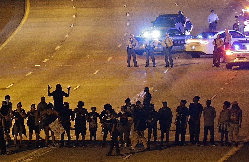 
              FILE - In this Sept. 22, 2016 file photo, police confront protesters blocking Interstate-277 during demonstrations following the police shooting of Keith Lamont Scott, in Charlotte, N.C. Emotionally wrenching politics, foreign conflicts and shootings at home took a toll on Americans in 2016, but they are entering 2017 on an optimistic note, according to a new poll that found that a majority believes things are going to get better for the country next year.  (AP Photo/Gerry Broome, File)
            