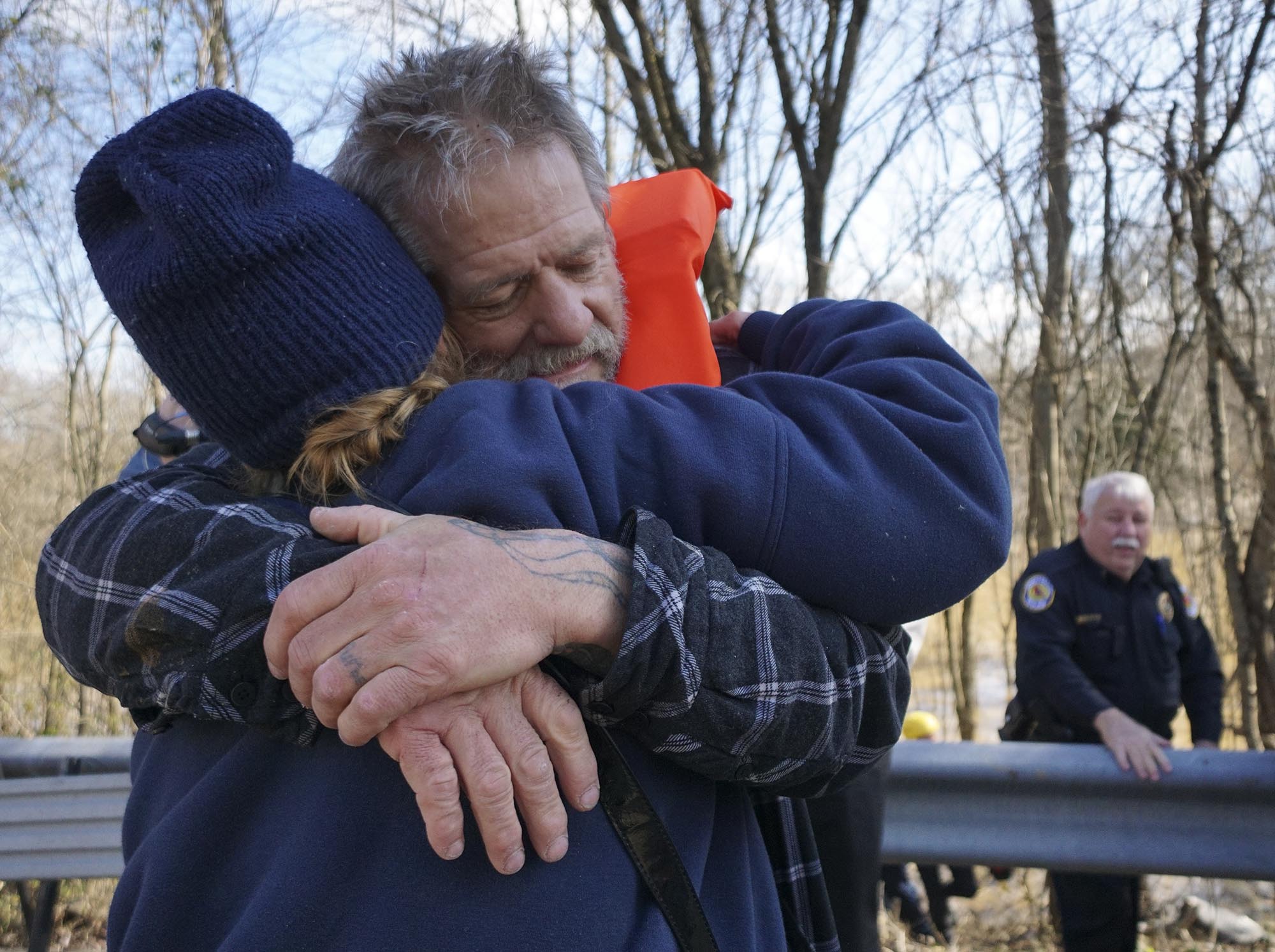 Staff Photo by Dan Henry / The Chattanooga Times Free Press- 2/4/16. Tim Nelson embraces his wife Sandy Nelson after being reduced by East Ridge Fire Rescue members when he became stranded in the rising waters of West Chickamauga Creek near Camp Jordan on Thursday, February 4, 2016. Nelson and Sandy are homeless and Nelson was swept 300-yards from the bridge he was living under suffering a minor case of Hypothermia.