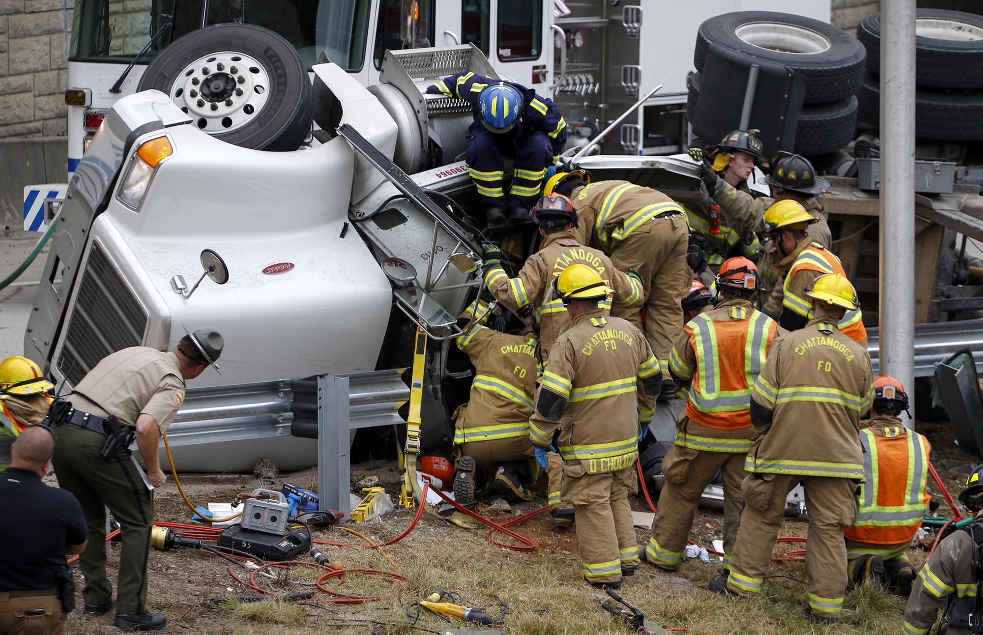 Staff Photo by Dan Henry / The Chattanooga Times Free Press- 7/6/16. Emergency personnel work to extract the driver of a tractor-trailer that rolled over while accessing TN-27 southbound from Signal Mountain Blvd. on Wednesday, July 6, 2016. The driver was transported by ambulance after workers spent over an hour to free him.