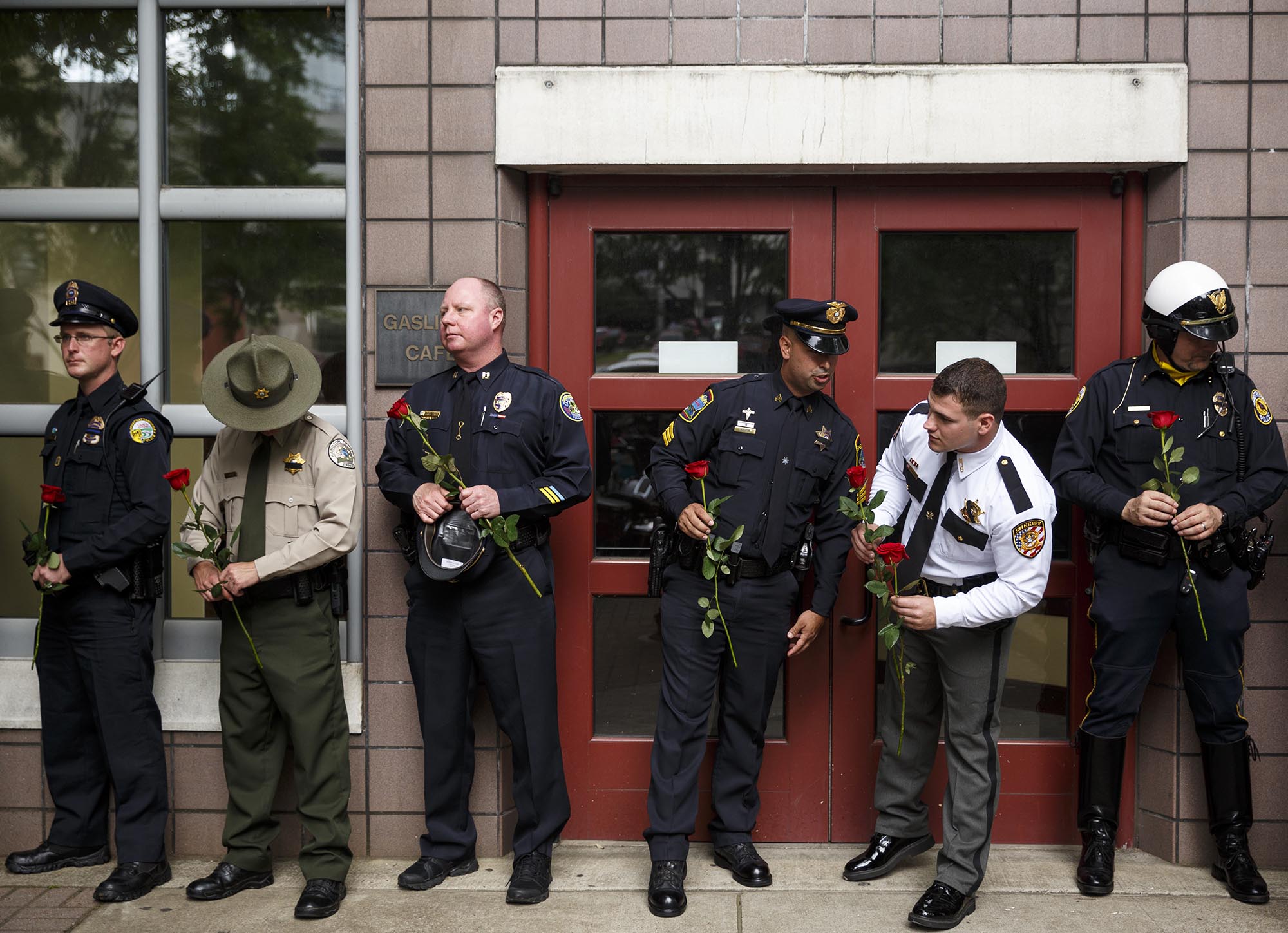 Law enforcement officers from around the region wait to lay roses during the annual Law Enforcement Memorial Ceremony on Market Street in front of the City-County Courts Building on Tuesday, May 10, 2016, in Chattanooga, Tenn. The annual ceremony honors the region's law enforcement officers who have lost their lives in the course of duty.