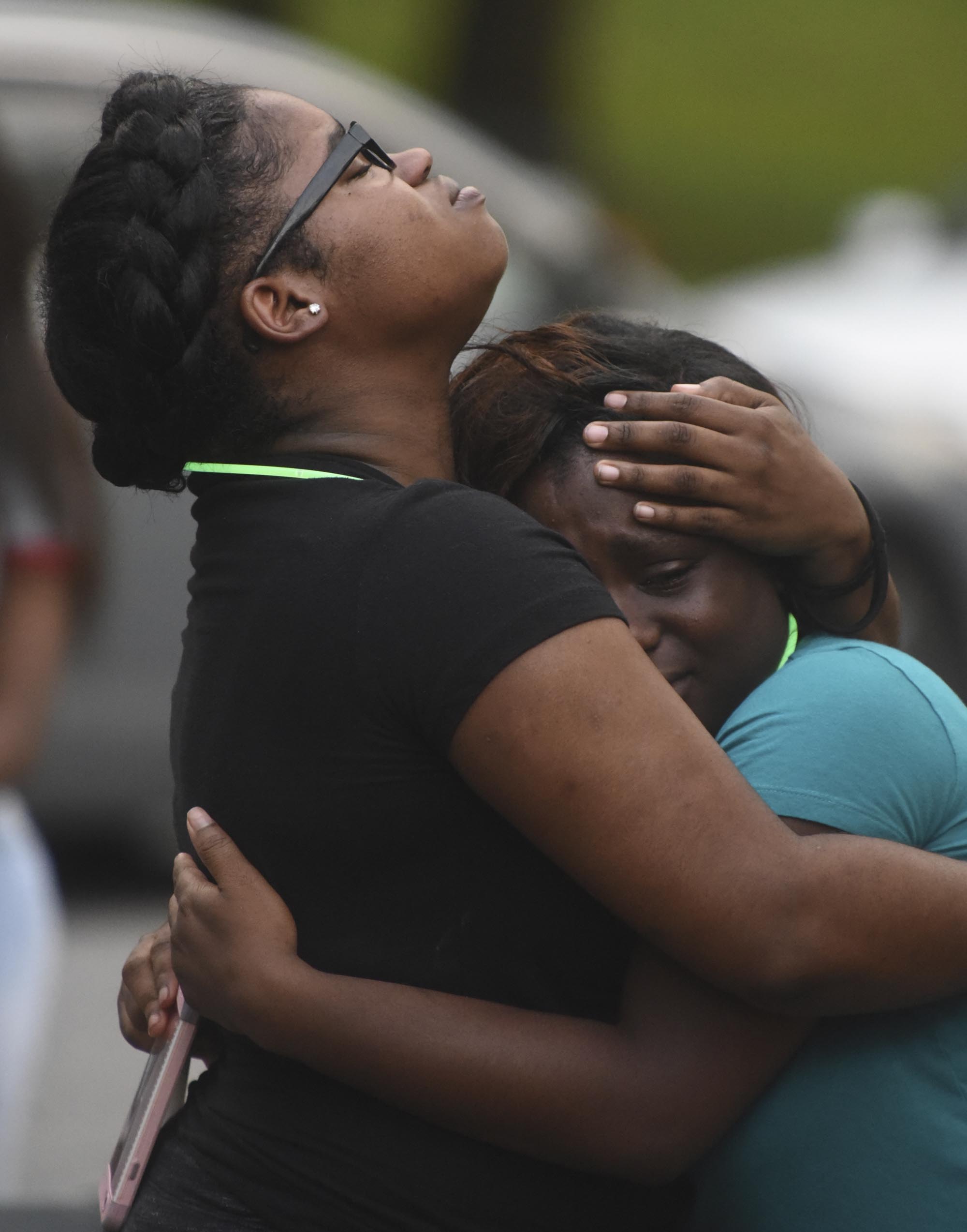 Treasure Strickland, left, and Keaira Colbert comfort each other during a vigil in memory of Ashley McKenzie at the corner of Cambridge Drive and Carousel Road Tuesday, June 14, 2016. McKenzie was killed late Monday night.