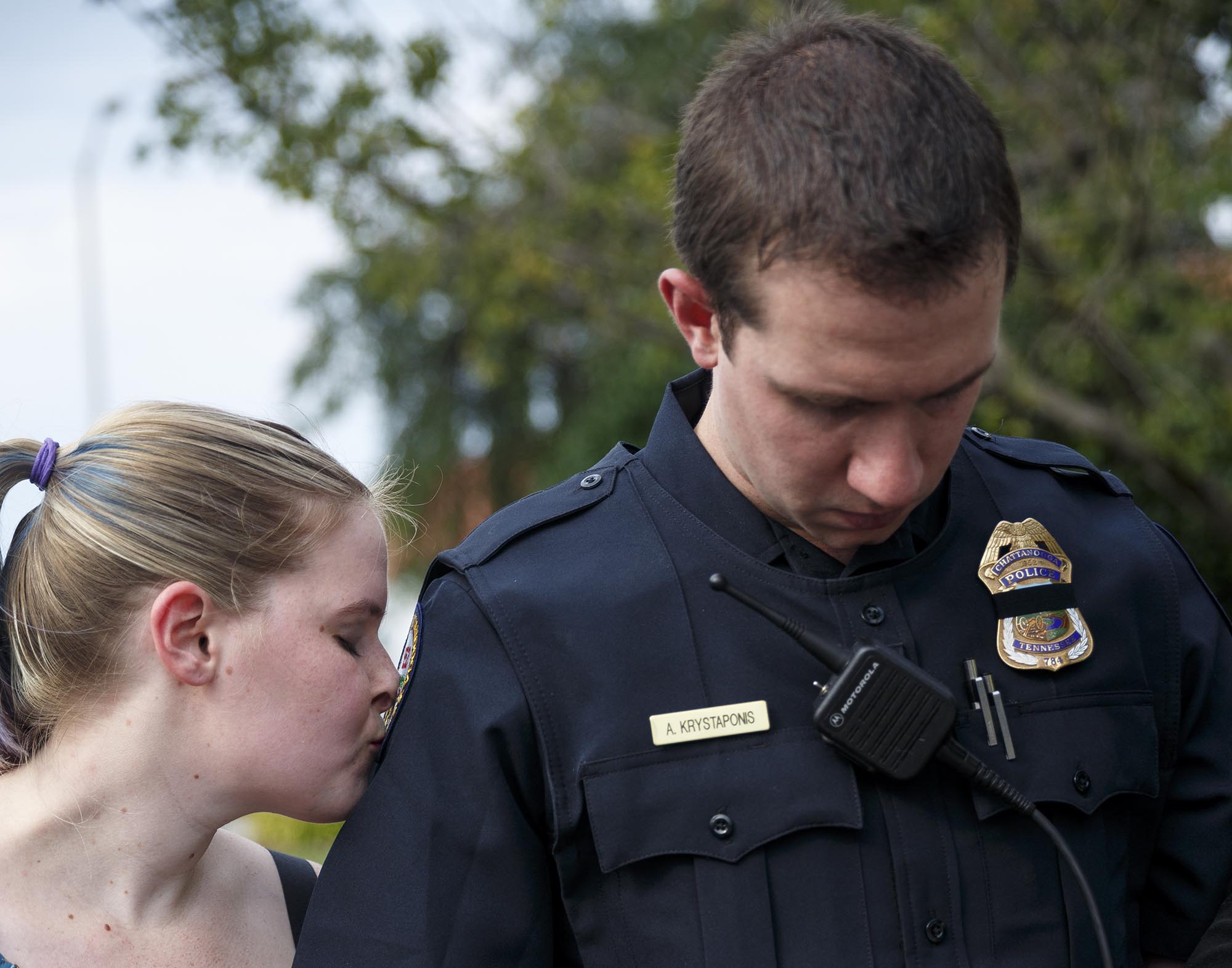 Waverly Krystaponis kisses the Chattanooga Police Department patch on her husband Officer Adam Krystaponis's uniform during an interfaith vigil outside the Chattanooga Police Services Center on Saturday, July 23, 2016, in Chattanooga, Tenn. The vigil was held as a show of solidarity between the community and police.