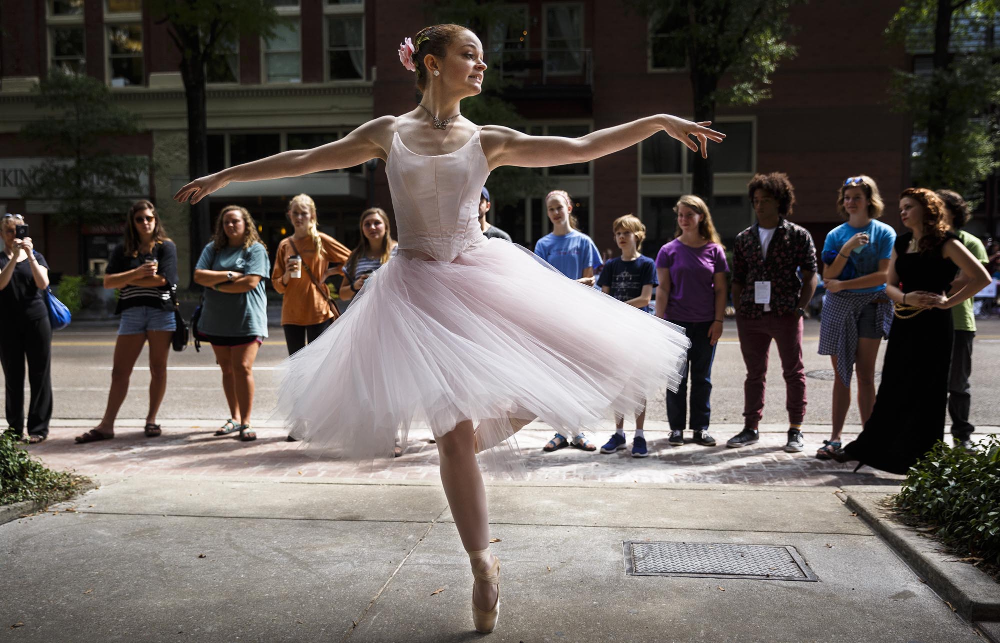 People watch from an empty parking space on Market Street as Caroline Blair with Chattanooga Ballet performs at the annual PARK(ing) Day event on Friday, Sept. 16, 2016, in Chattanooga, Tenn. Artists and businesses temporarily took over parallel parking spaces in downtown Chattanooga with art displays and demonstration booths.