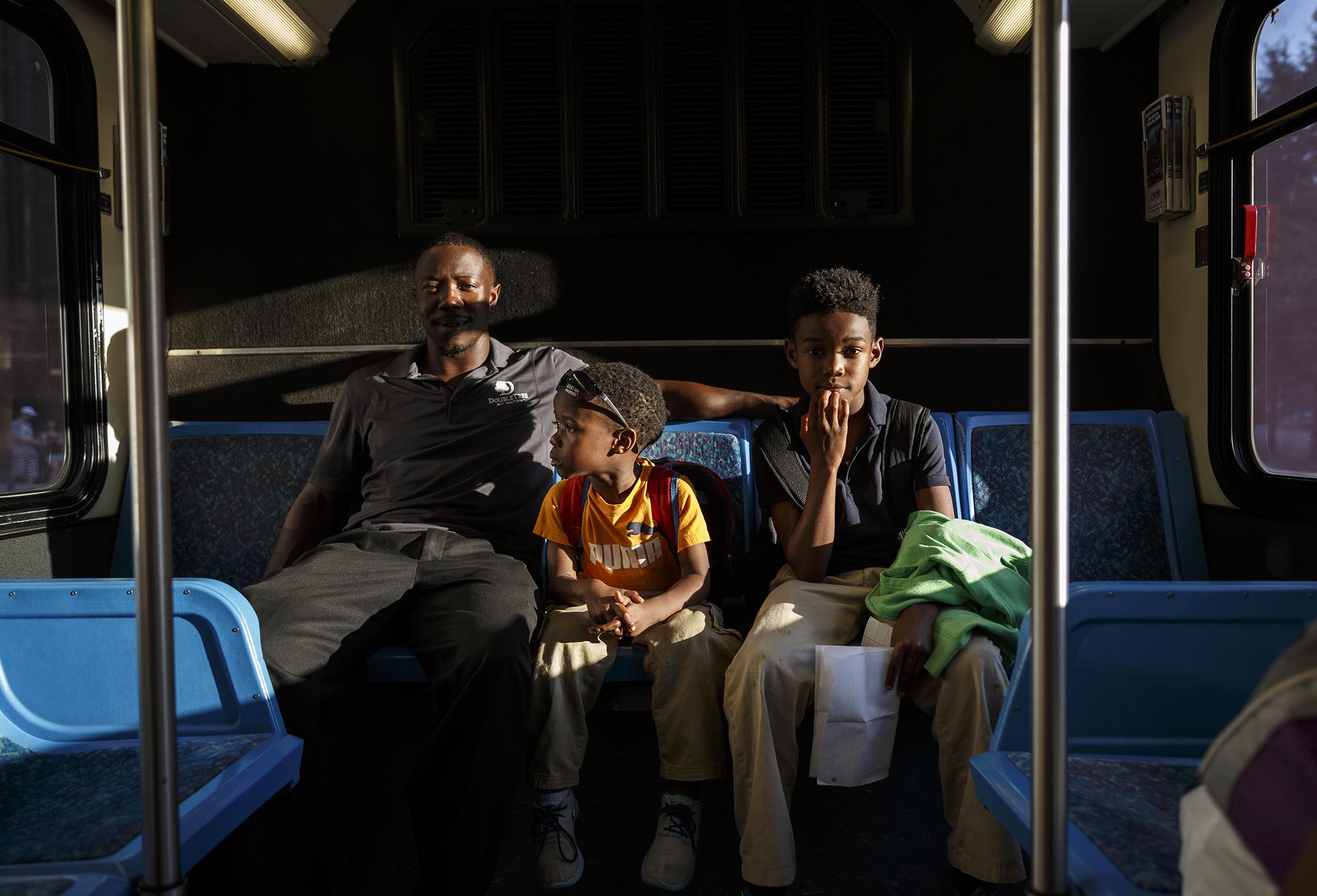 Tim Jones, left, rides a bus home from the Chambliss Center, where his sons Tariq, center, and Timothy go to school, in September of 2015. Without a car, picking up his kids from school involves a lengthy bus journey to make the 9 mile round trip from downtown to Brainerd.
