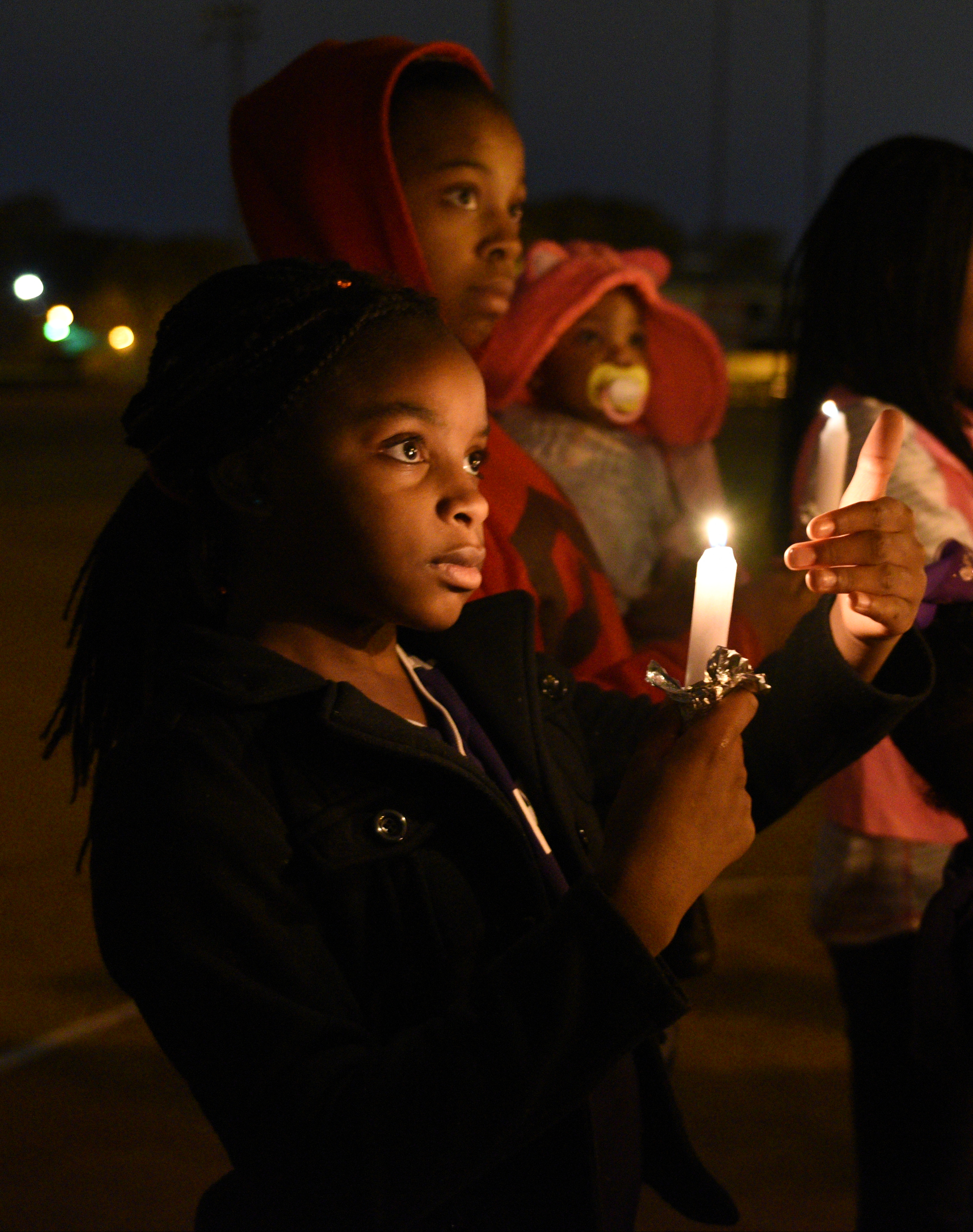 Cari Ellison, front, holds a candle Wednesday, Nov. 23, 2016, at East Lake Recreation Center. Several people gathered to memorialize Zoie Nash, who was killed in a bus crash this week.
