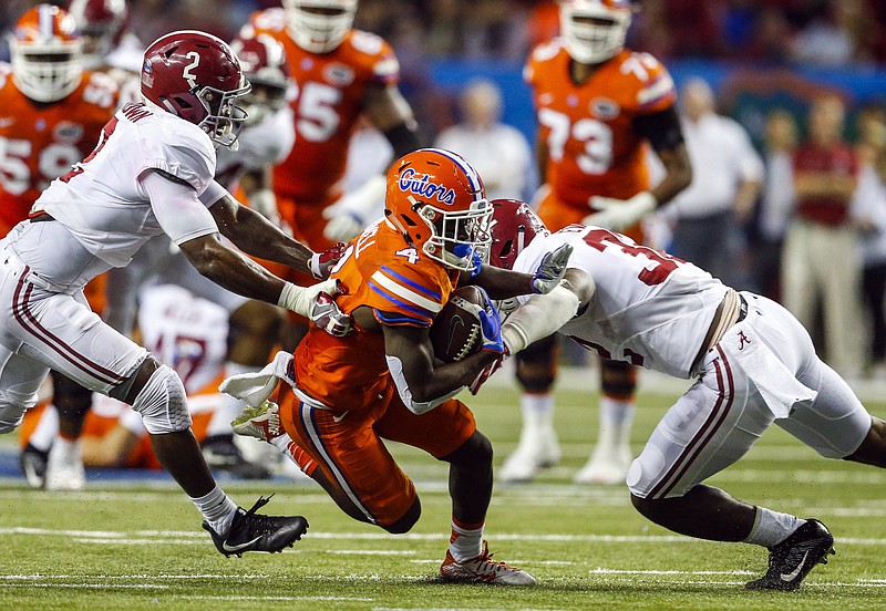 Florida wide receiver Brandon Powell (4) is tackled by Alabama defensive back Tony Brown (2) and Alabama linebacker Rashaan Evans (32) during the first half of the Southeastern Conference championship NCAA college football game, Saturday, Dec. 3, 2016, in Atlanta.(AP Photo/Butch Dill)