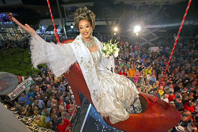 
              FILE - In this Thursday, Dec. 31, 2015, file photo, provided by the Florida Keys News Bureau, female impersonator Gary Marion, known as Sushi, hangs in a giant replica of a woman's high heel shoe in Key West, Fla. Beginning at about 11:59 p.m. Thursday, the shoe with Sushi in it is to be lowered to Duval Street to mark the beginning of 2016. The Big Red Shoe Drop is one of several of the subtropical island city's takeoffs on New York City's Times Square ball drop. (Rob O'Neal/Florida Keys News Bureau via AP, File)
            