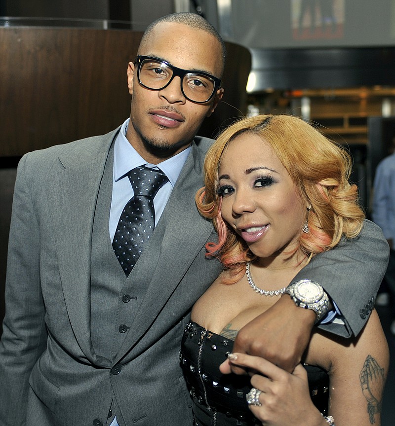 
              FILE - In this Oct. 3, 2010 file photo, Grammy award winning artist Clifford "TI" Harris, left, poses for media with his wife Tameka "Tiny" Harris, right, during an Alzheimers "For the Love of Our Fathers" foundation honoree luncheon at the Luckie Lounge in Atlanta. The wife of rapper T.I. has filed for divorce from the hip-hop entertainer. Henry County Court records show Tameka “Tiny” Harris filed for divorce after six years of marriage with the 36-year-old rapper.  (AP Photo/Gregory Smith, File)
            