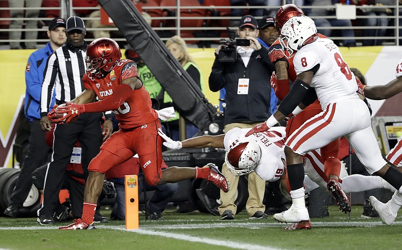 
              Utah running back Joe Williams, left, scores against Indiana during the first half of the Foster Farms Bowl NCAA college football game Wednesday, Dec. 28, 2016, in Santa Clara, Calif. (AP Photo/Marcio Jose Sanchez)
            