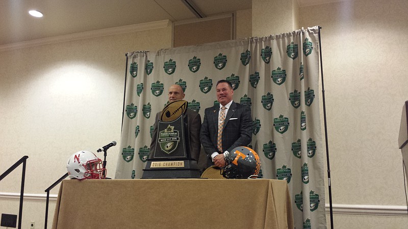 Nebraska coach Mike Riley (left) and Tennessee coach Butch Jones (right) pose with the Music City Bowl trophy during a joint press conference the day before the Cornhuskers and Vols play in Nashville.