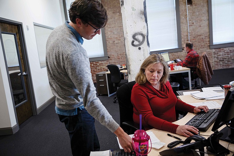 COO Andrew Hetzler, left, talks with license agent Sandra White at American Exchange in Chattanooga. The company, created to help the public navigate the Affordable Care Act health care exchange, now has an uncertain future as a Republican-controlled U.S. government seeks to repeal the law.