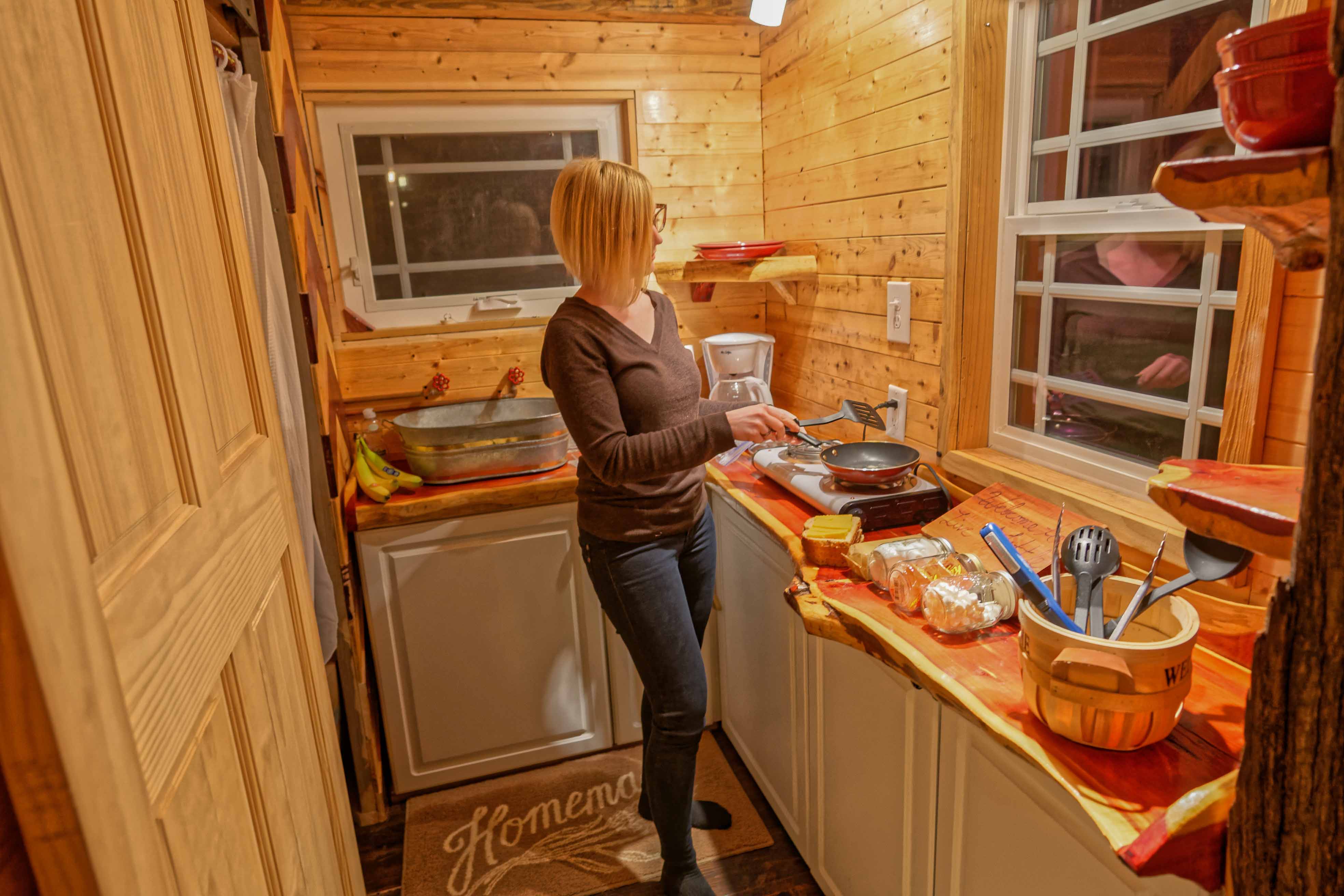 Writer Sunny Montgomery prepares dinner in her tiny home, an effort that results in her first tiny-life lesson: Deal with your messes before they get out of hand. (Photo by Jennifer Woods)