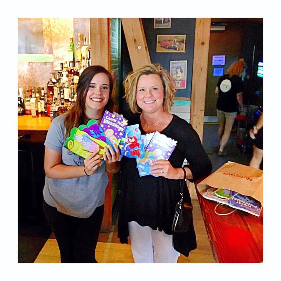 Kelsey Butler stands with Karen Sneed, a woman who asked her husband for an anniversary gift of books for HomeBound.