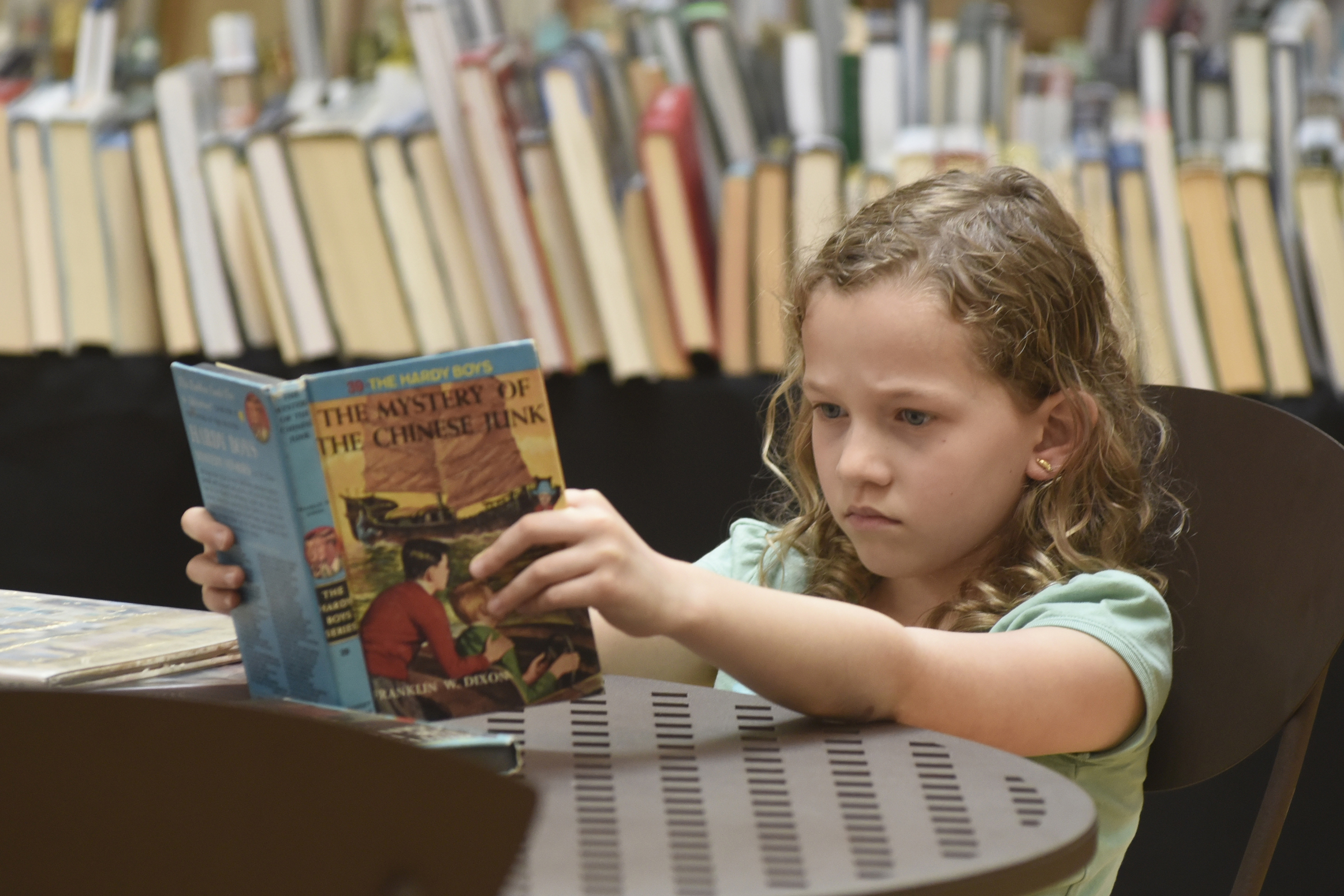 Elie Graeber reads during the annual Friends of the Library book sale at the Eastgate Town Center.