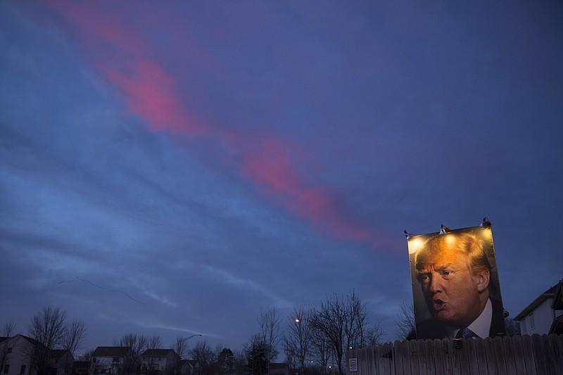 A billboard-sized photo of Donald Trump, complete with lighting, that George Davey mounted on the fence of his home in West Des Moines, Iowa, last January. Davey said he meant for the intent — support or opposition — to be ambiguous. Associated Press