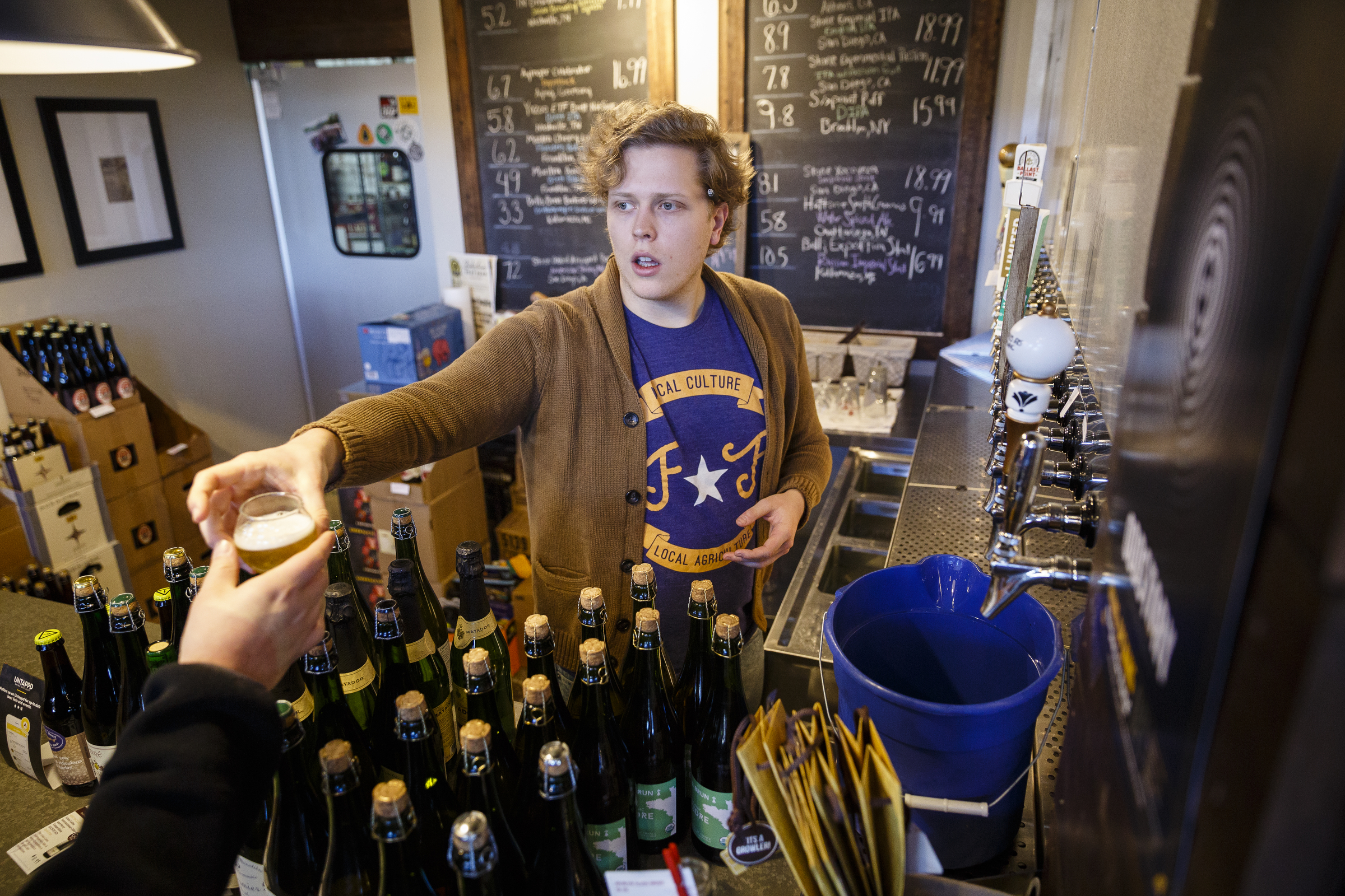 Beer specialist Calvin Cummings hands a customer a sample from a tap at Imbibe liquor store on Thursday, Dec. 29, 2016, in Chattanooga, Tenn. On Jan. 1, a new state law increases the alcohol by volume cap for beer from 6.2% to 10.1% which will allow grocery stores and breweries to sell high-gravity beers which could previously only be sold at liquor stores.