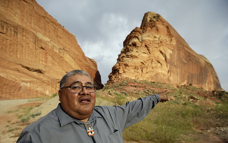 
              FILE - This June 21, 2016, file photo, Malcolm Lehi, a Ute Mountain Tribal Commissioner points to a rock formation near Blanding, Utah. "We don't want to forget about our ancestors," said Lehi. "Through them we speak. That's the whole concept of protecting and healing this land. They are still here among us as the wind blows." President Barack Obama designated two national monuments Wednesday, Dec. 28, at sites in Utah and Nevada that have become key flashpoints over use of public land in the U.S. West. (AP Photo/Rick Bowmer, File)
            