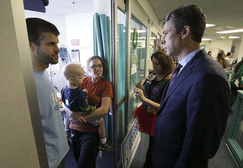 Bob Adams, his wife Lally and their two-year-old Caelan speak to Chattanooga City Mayor Andy Berke after Berke pledged the City of Chattanooga will donate $1 million in honor of the Woodmore bus crash victims to help build a new Children's Hospital.
