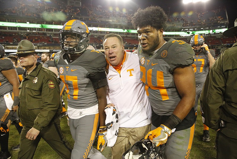 Tennessee football coach Butch Jones, center, talks with linebacker Darrin Kirkland, Jr., right, and wide receiver Brandon Johnson after their Music City Bowl victory against the Nebraska Cornhuskers at Nissan Stadium on Friday, Dec. 30, 2016, in Nashville, Tenn. Tennessee won 38-24.